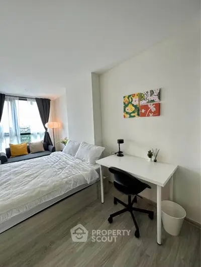 Modern bedroom with study area, featuring a cozy bed and stylish decor, perfect for urban living.