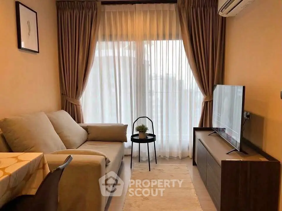 Cozy living room with modern sofa, TV, and elegant curtains in a stylish apartment.
