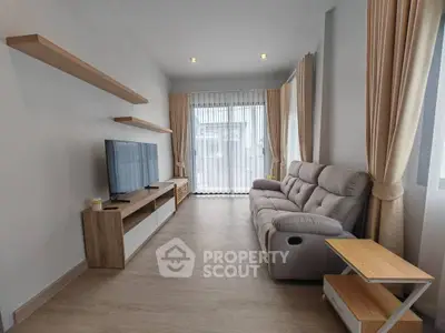 Modern living room with sleek furniture and large windows for natural light.