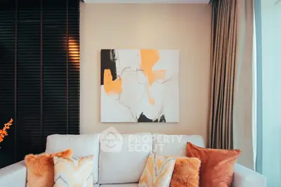 Stylish living room with modern art and cozy cushions on a plush sofa, perfect for relaxation.