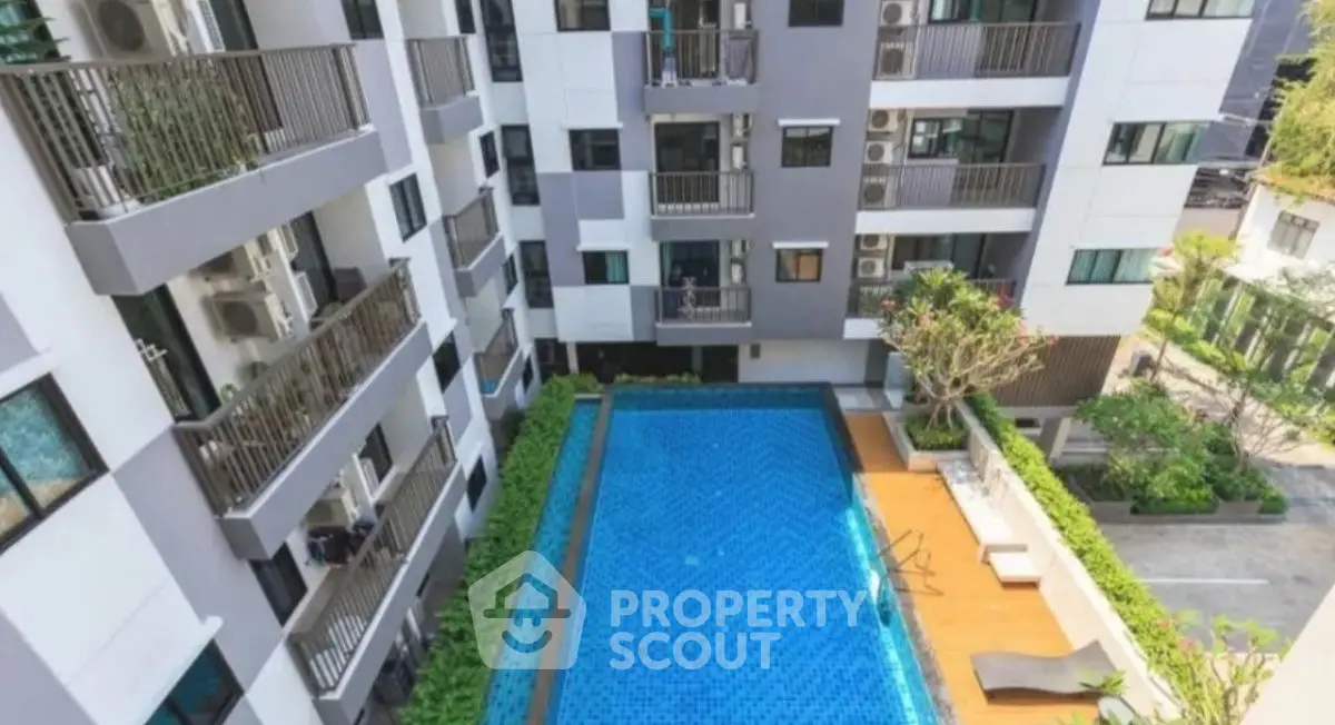 Modern apartment complex with a stunning outdoor pool and lush greenery.