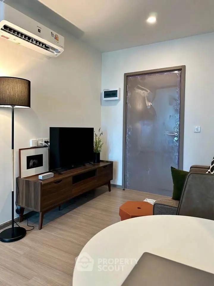 Modern living room with sleek furniture and wall-mounted air conditioner
