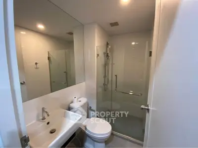 Modern bathroom with glass shower and sleek fixtures in a contemporary apartment.