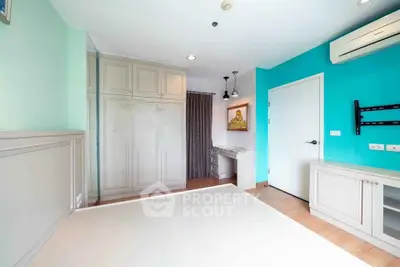 Spacious bedroom with modern decor and built-in storage in a bright apartment.