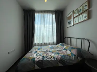 Cozy bedroom with modern decor and large window offering natural light