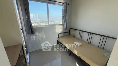 Cozy bedroom with single bed and stunning city view from window.