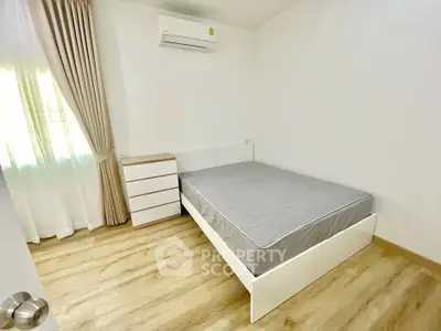 Bright minimalist bedroom with wooden flooring and air conditioning