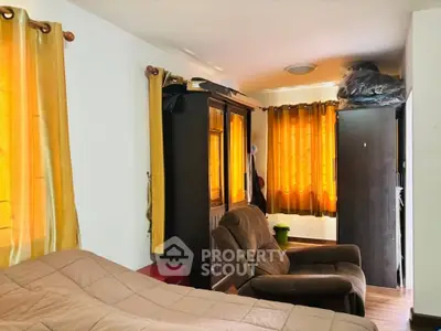 Cozy bedroom with warm lighting and comfortable seating area.