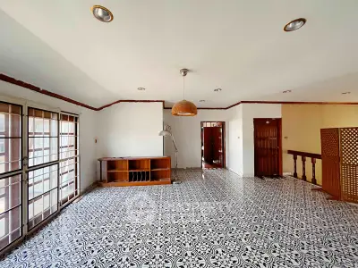 Spacious living room with patterned tile flooring and ample natural light.