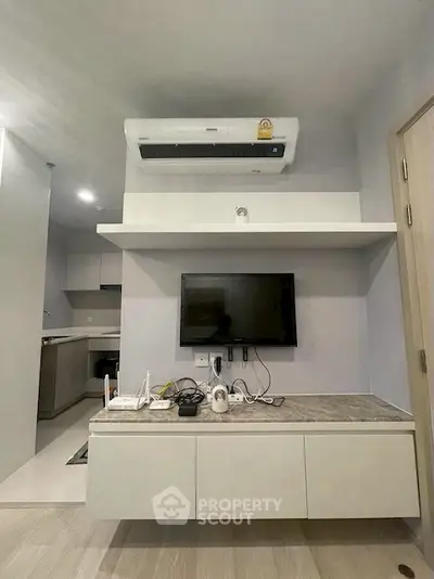 Modern living room with wall-mounted TV and air conditioning unit