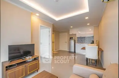 Modern living room with open kitchen, sleek furniture, and ambient lighting.