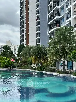 Luxurious residential building with stunning pool and lush greenery, perfect for modern living.