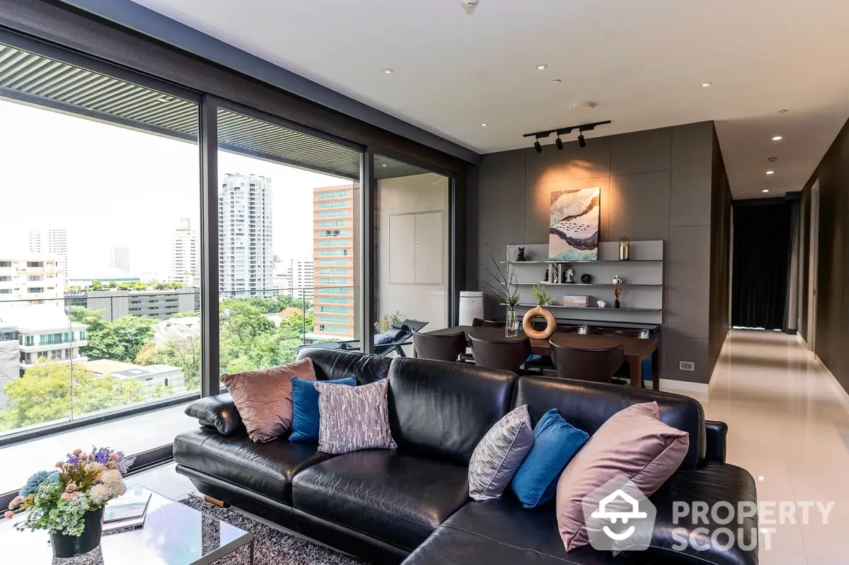 Luxurious living room with sleek black leather sofa, modern decor, and expansive city view through floor-to-ceiling windows, perfect for upscale urban living.