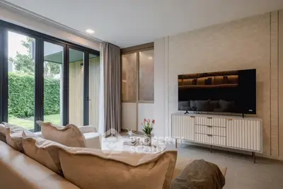 Modern living room with stylish decor and large windows overlooking garden.