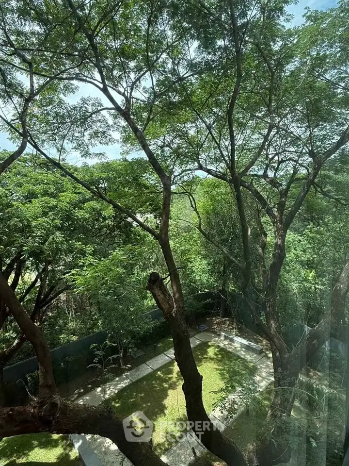 Lush green garden view from a high-rise apartment, offering serene and tranquil surroundings.