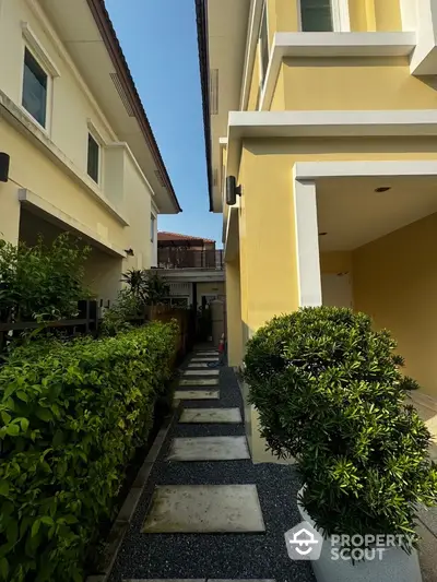 Charming exterior walkway with lush greenery and modern architecture