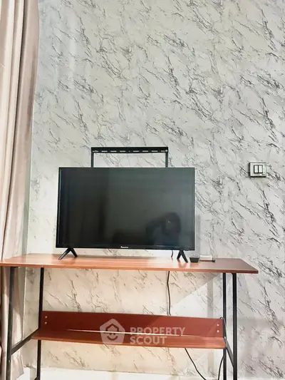 Modern living room with marble accent wall and sleek TV setup.