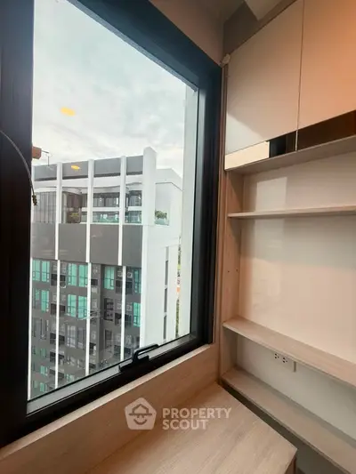 Modern apartment interior with built-in shelves and city view from window
