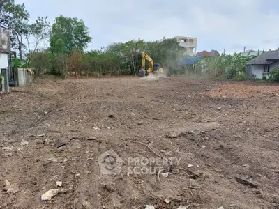 Spacious cleared land ready for development with excavator in action, ideal for new construction projects.