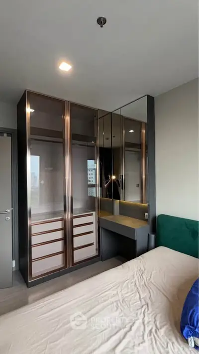 Modern bedroom with mirrored wardrobe and cozy bed in stylish apartment.