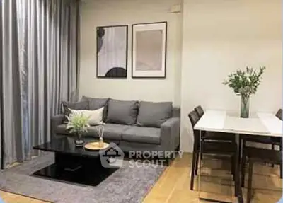 Modern living room with stylish decor and dining area, featuring a cozy gray sofa and elegant dining table.