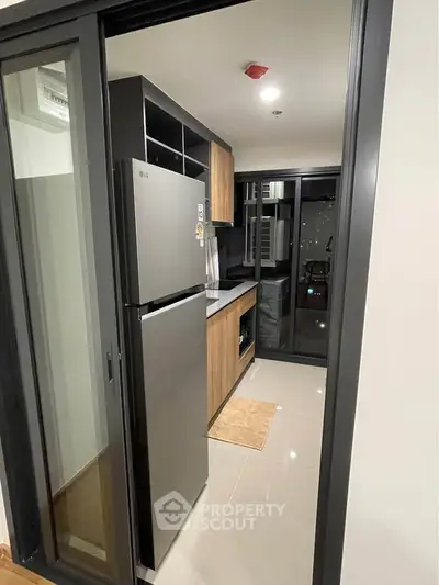 Modern kitchen with sleek appliances and stylish cabinetry in a contemporary apartment.