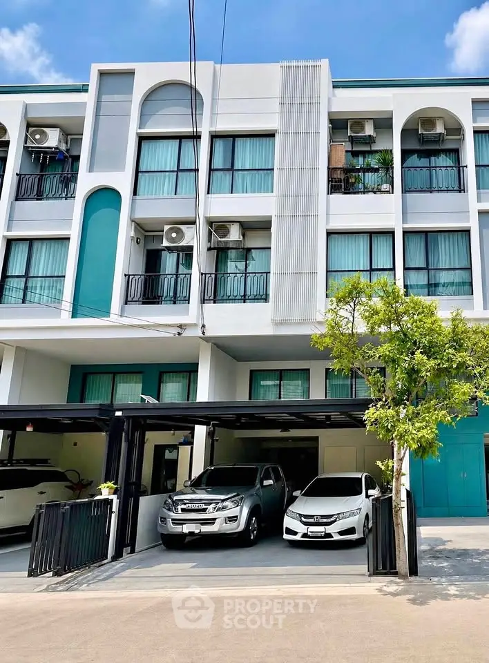 Modern townhouse exterior with parking space and contemporary design.