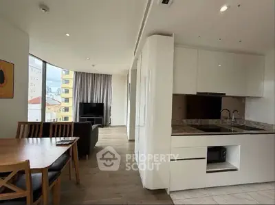 Modern open-plan kitchen and living area with sleek design and ample natural light.