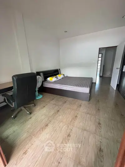 Spacious bedroom with modern furniture and wooden flooring