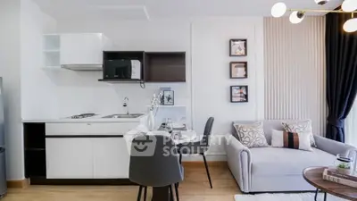 Modern open-layout kitchen and living room with stylish decor and cozy seating area.