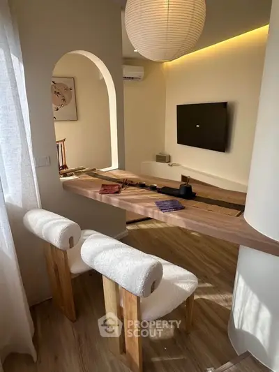 Stylish modern living room with wooden flooring, elegant furniture, and ambient lighting.