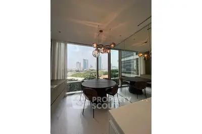 Modern dining area with city view, featuring stylish lighting and floor-to-ceiling windows.