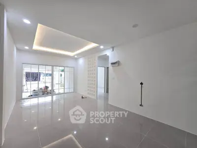 Spacious modern living room with sleek tile flooring and recessed lighting