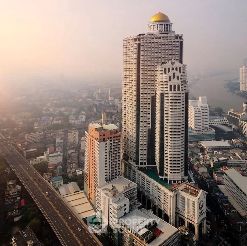Stunning aerial view of a modern high-rise building with river backdrop, perfect for luxury urban living.
