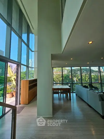 Luxurious modern living room with floor-to-ceiling windows and stunning city view.