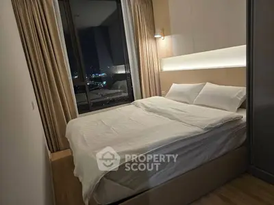 Modern bedroom with city view, featuring cozy bed and ambient lighting for a relaxing atmosphere.