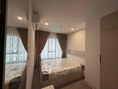Modern bedroom with large windows and stylish curtains in a contemporary apartment.
