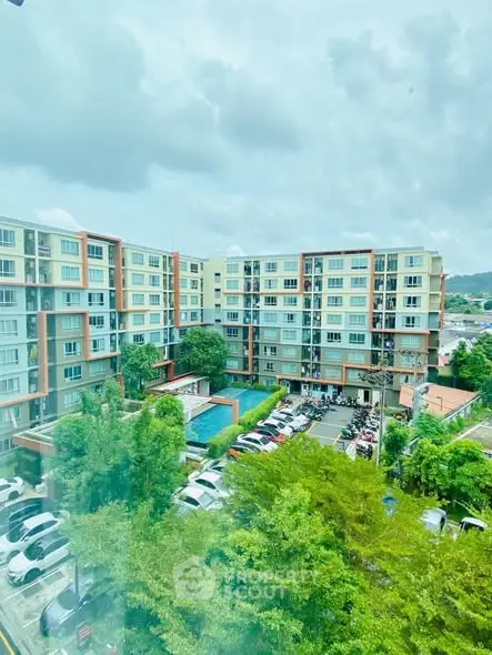 Stunning view of modern apartment complex with lush greenery and ample parking space.