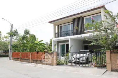 Charming two-story house with carport and lush garden in a serene neighborhood.
