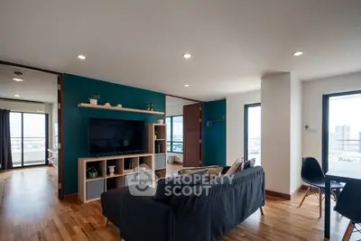 Spacious modern living room with stylish decor and city view, perfect for urban living.