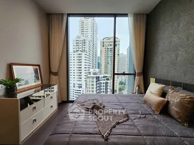 Luxurious bedroom with stunning city view, modern decor, and large window in high-rise apartment.