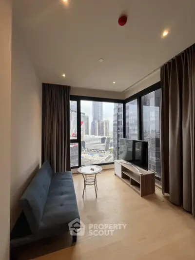 Modern living room with city view, featuring sleek furniture and large windows.