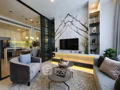 Luxurious modern living room with marble accent wall and open kitchen layout.