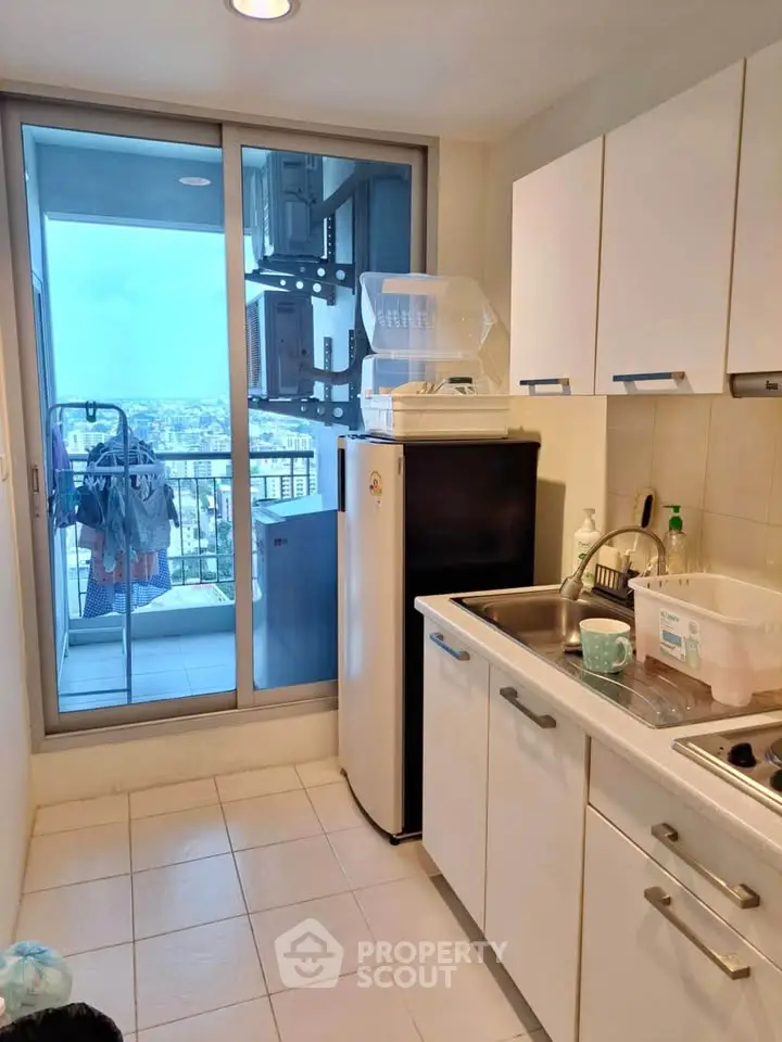 Compact kitchen with balcony view, featuring modern appliances and ample storage space.