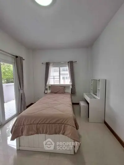 Cozy bedroom with single bed and balcony access in modern apartment