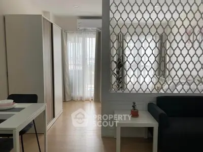 Modern apartment interior with stylish partition, cozy living area, and natural light.