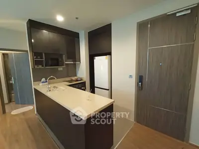 Modern kitchen with sleek design and open layout, featuring a built-in oven and stylish cabinetry.