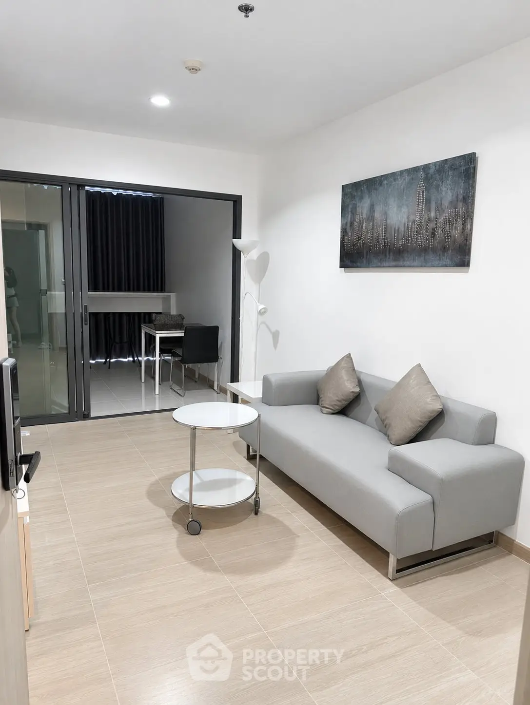 Modern living room with sleek gray sofa and stylish decor in a contemporary apartment.