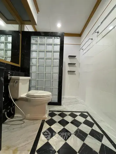 Luxurious bathroom with elegant black and white marble design and glass block wall.