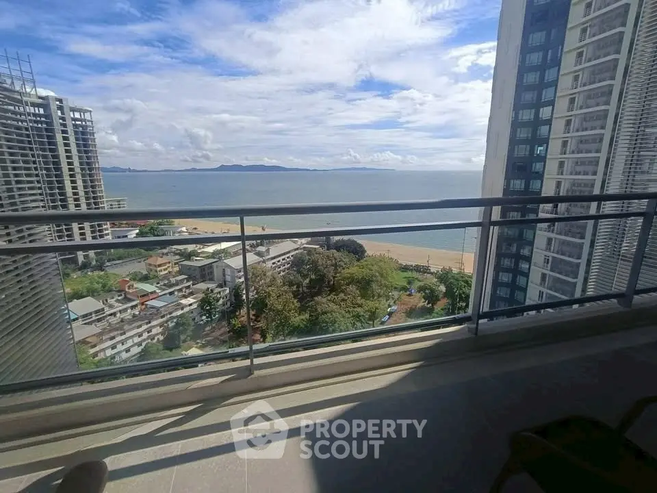 Stunning beachfront balcony view with expansive ocean and cityscape panorama.